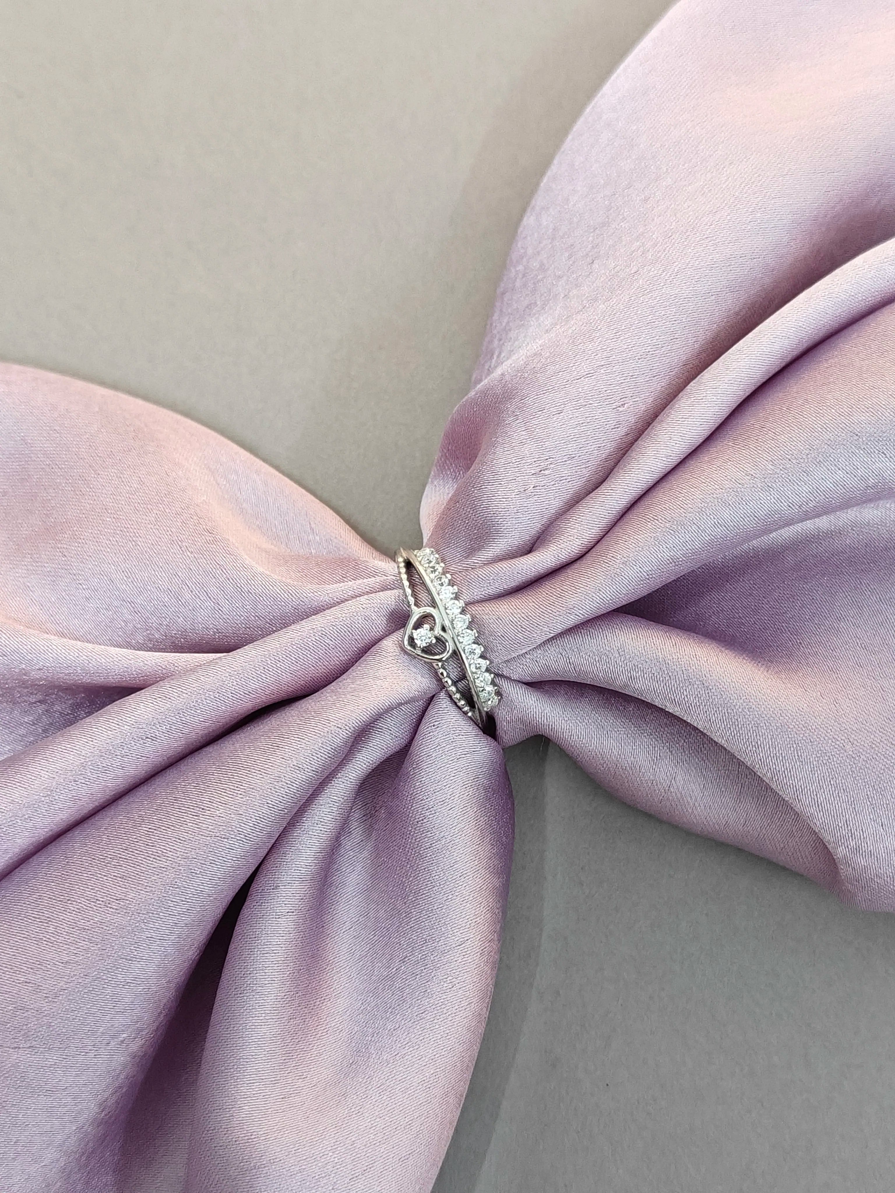 Silver ring on a folded light purple fabric